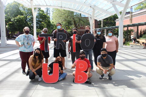 TRIO members holding letters that say TRIO UB
